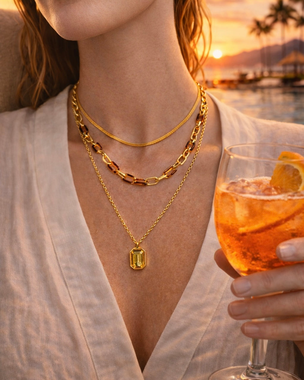 The Aura stack a collection of 3 necklaces in a stack on a model on the beach