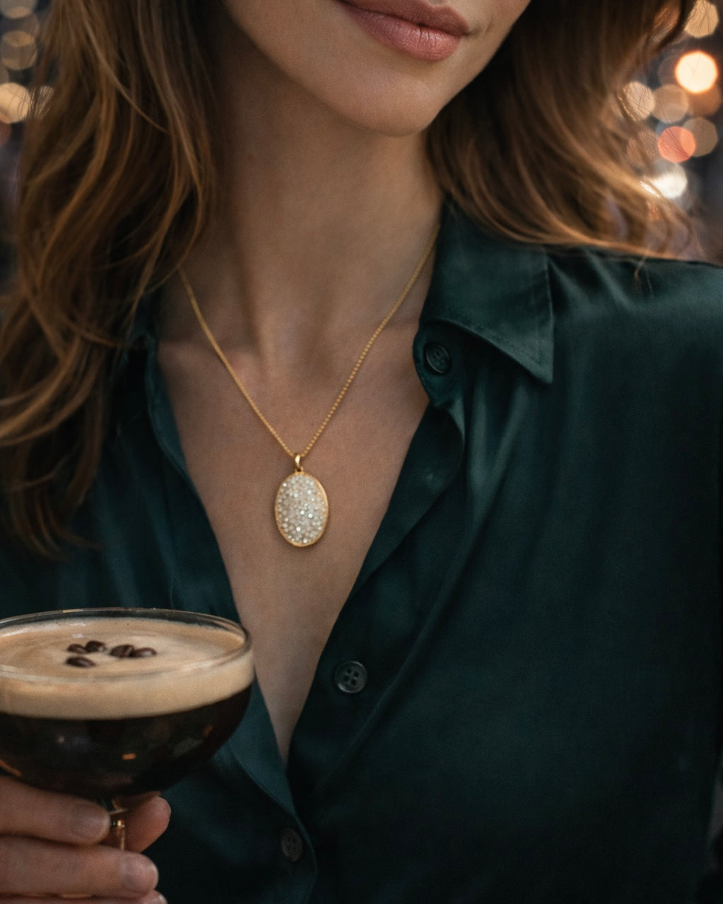 The Lumina Pendant gold necklace styled on model with espresso martini