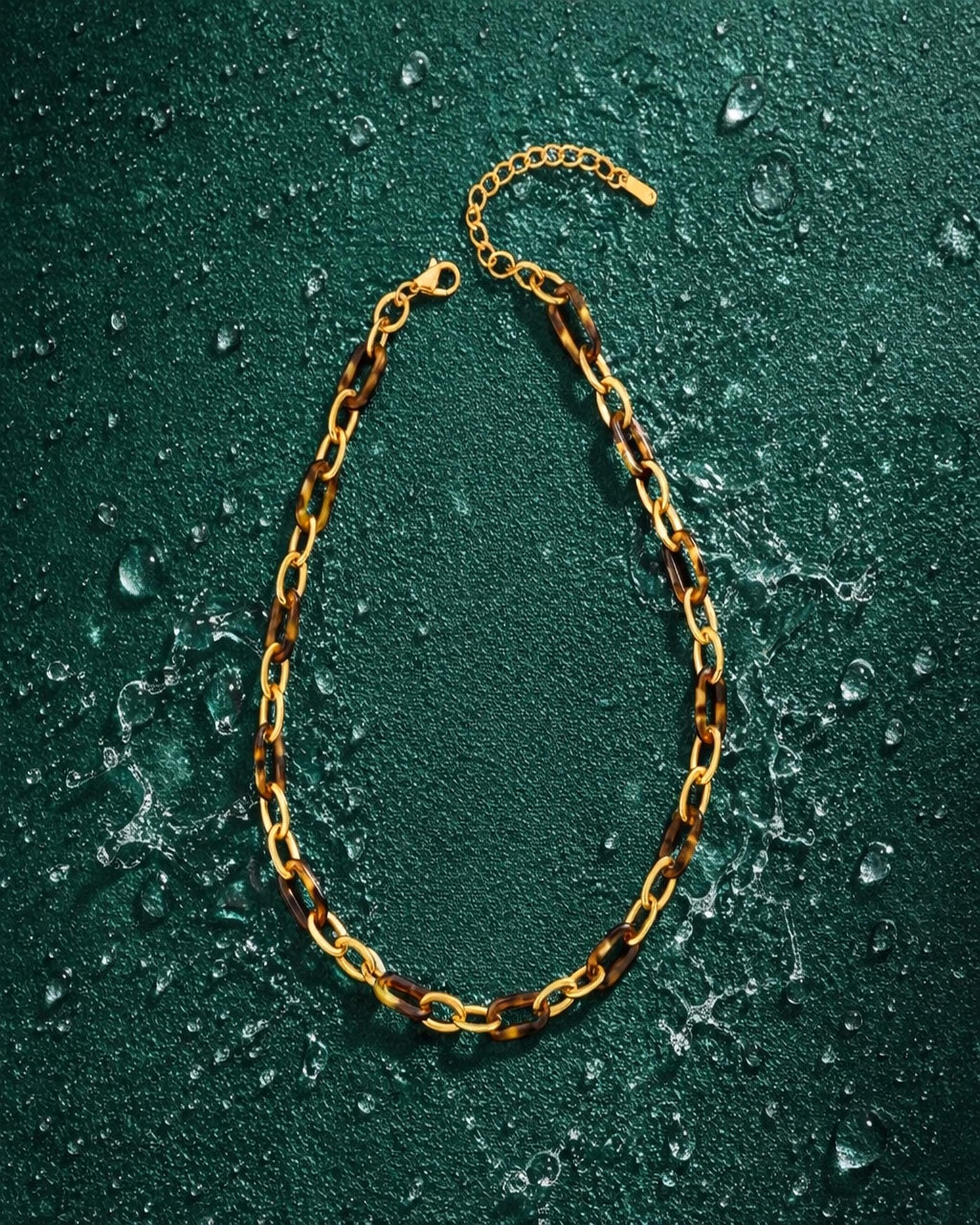 The Tortoise Link textured gold chain necklace on deep jade background